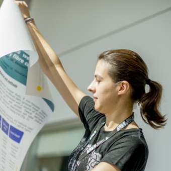 PhD unrolling her PhD poster