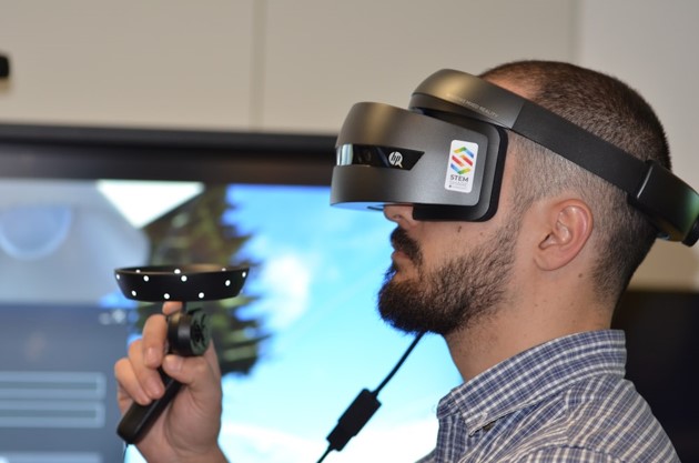 Side view of person wearing virtual reality headset and holding controller