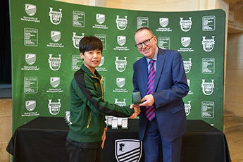 Meng Zhou receiving award and shaking hands with Professor Jeremy Gregory