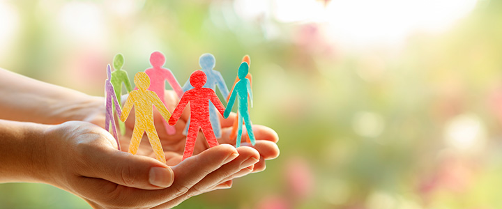 Social inclusion concept - paper people silhouettes on hands