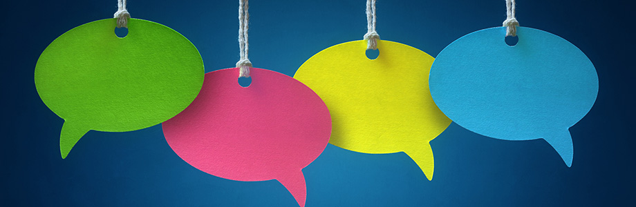 Four brightly coloured empty speech bubbles on a dark blue background