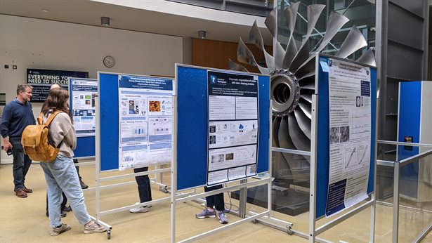 Staff from the Faculty of Engineering reading research posters displayed in the ESLC building