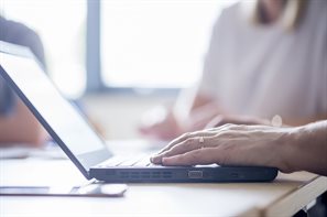 Hand typing on a laptop