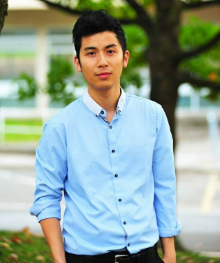 Photo of David Li standing in front of a road and a tree.