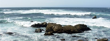 Waves breaking over rocks at a beach on 17 Mile Drive, California. 