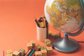 A globe next to a pot of coloured pencils and assorted wooden blocks