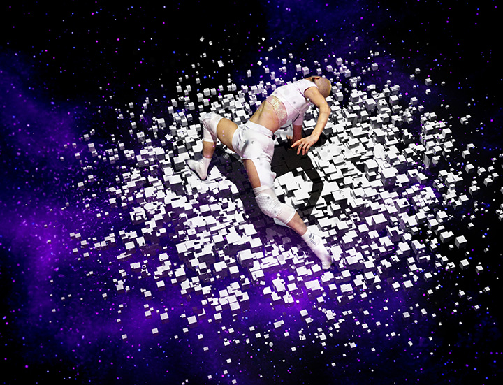 A photo of a dancer under a spotlight on a purple lit stage