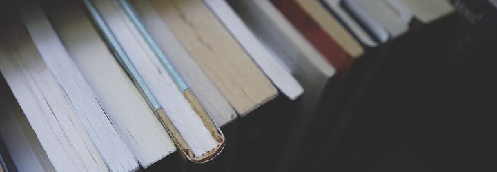 Downward shot of book spines and pages against a dark background (photo)