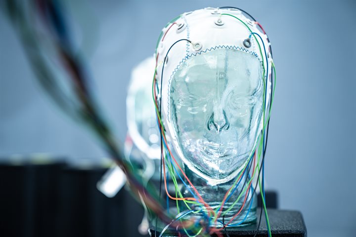 A transparent head, wearing a cap with electrodes coming from it