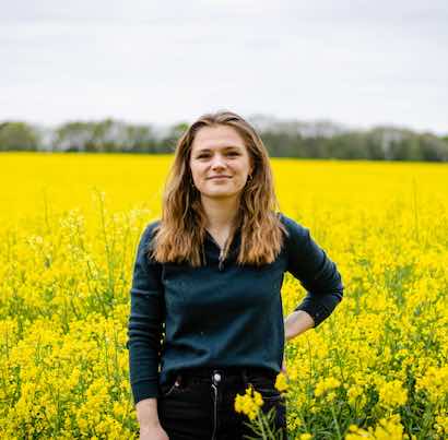 Lisa Humbert standing in a yellow rapeseed field