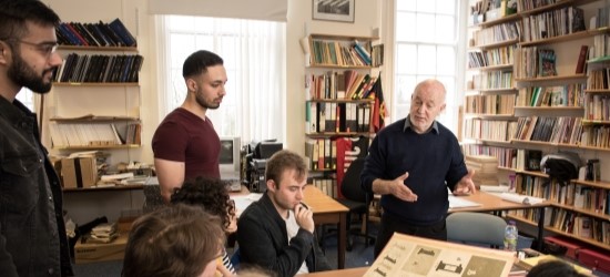 Academic and students in library looking at archive publications