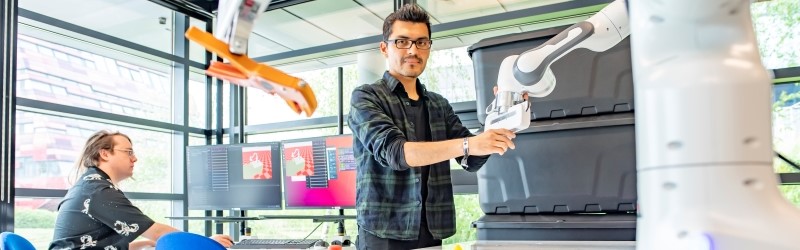 Two researchers working with a robot in lab