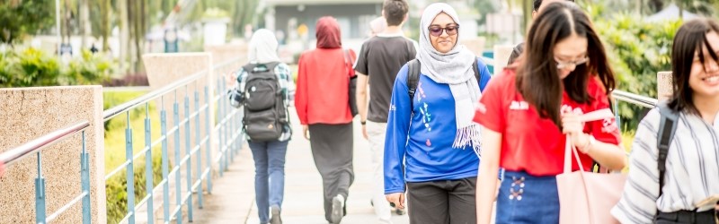 Mixed groups of students walking across bridge