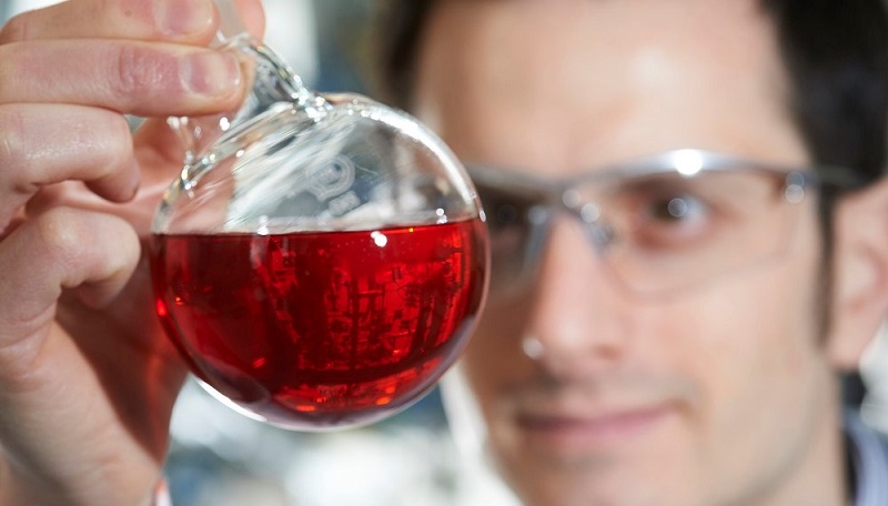 Close up of researcher viewing chemical flask
