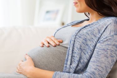 Pregnant woman with hands on baby bump