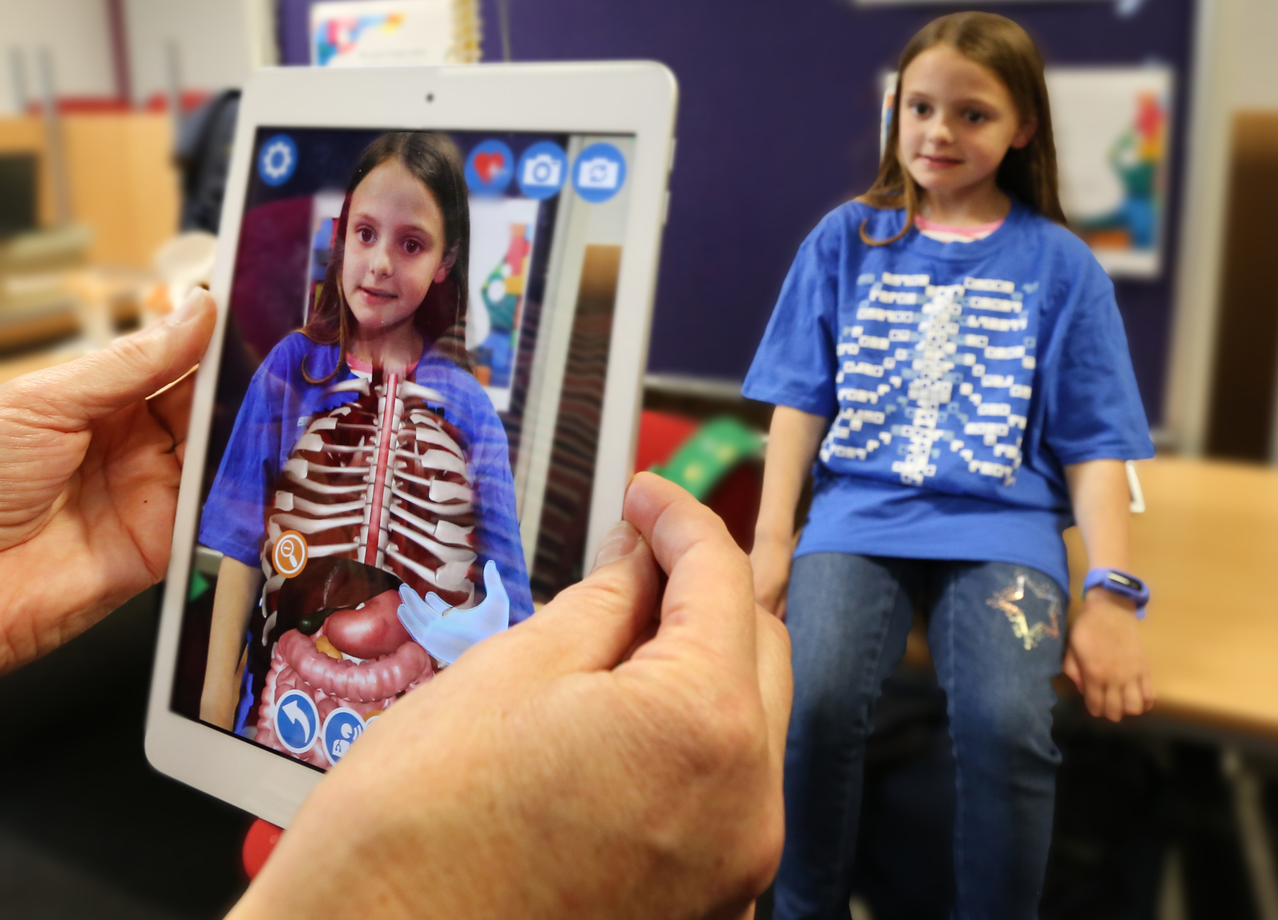 child in VR tshirt with ipad showing xray of insides