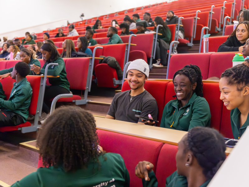 Students chat in lecture theatre in sports clothing