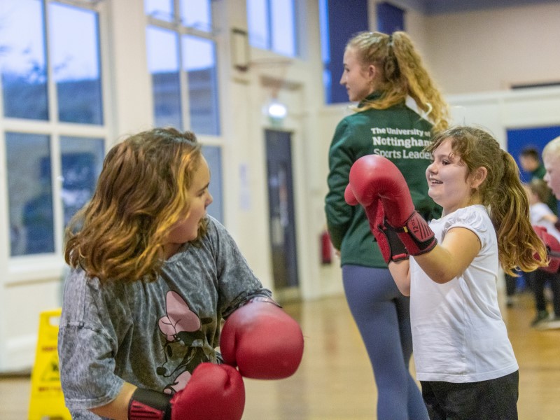 School girls try boxing in school hall