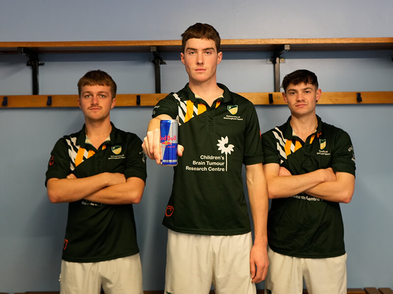 The men's hockey team holding a Red Bull can in the changing room ahead of their Headliner