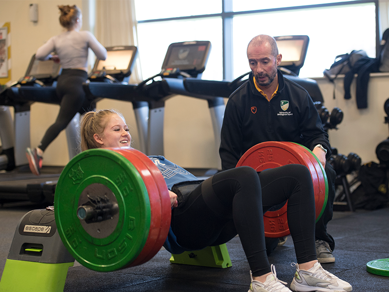 A fitness instructor guiding a student through their training in the fitness suite at Sutton Bonington Sports Centre