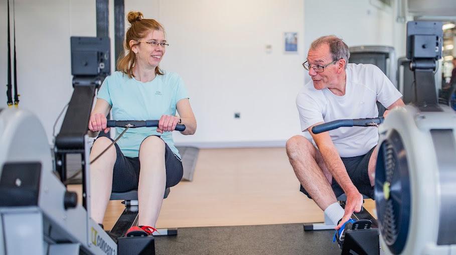 Two members working out on the rowing machines in the fitness suite at David Ross Sports Village