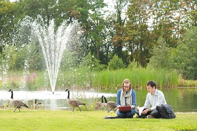 Two undergraduate students talking by fountain on Jubilee campus lake