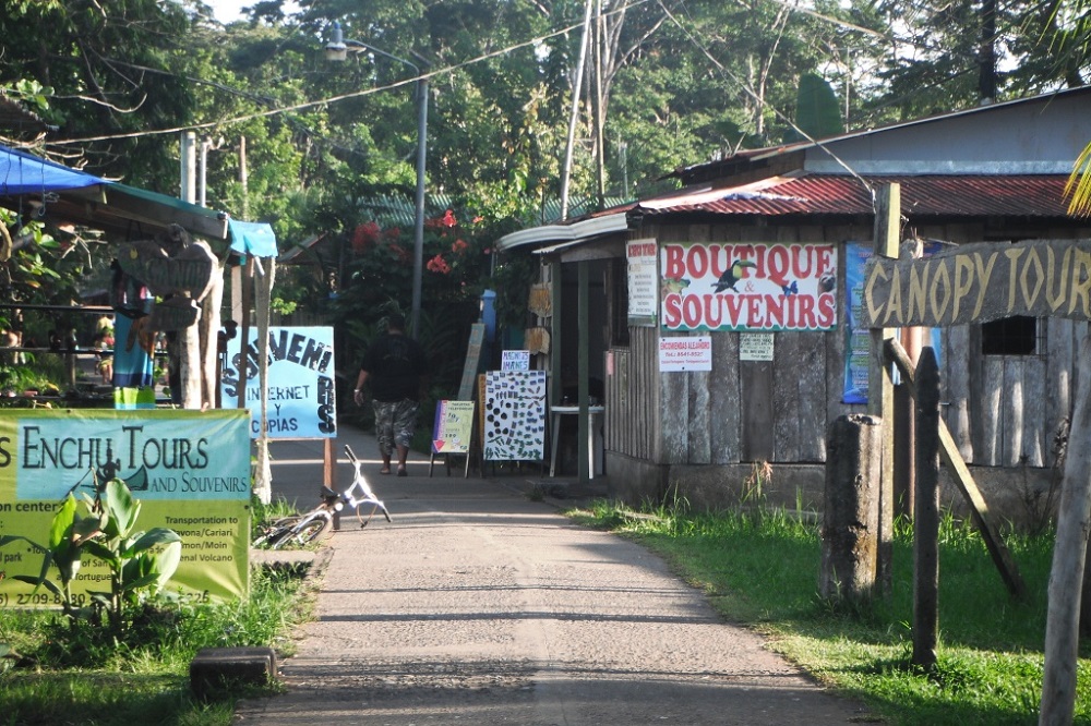 A tourist area in Costa Rica. A number of buildings are displaying signs advertising souvenirs and tours.