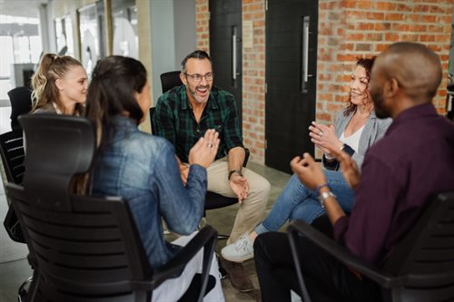 A diverse group of business people sat in a circle having a discussion.