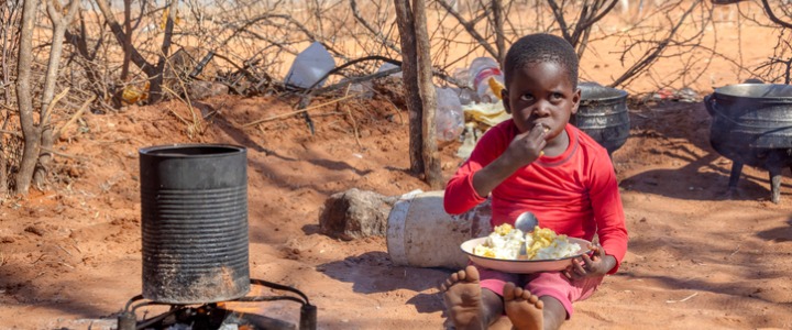 African child in a village eating
