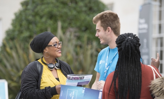 Student ambassador helping a parent and prospective student at an open day