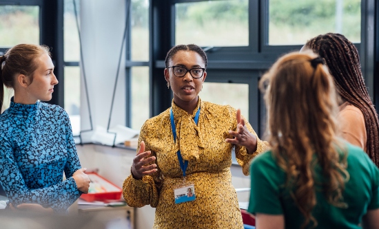 A woman talking to other women in a group situation at work