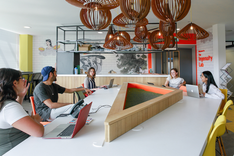 Students at a shared desk with laptops