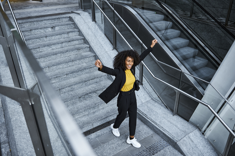 Person with their arms up on a staircase