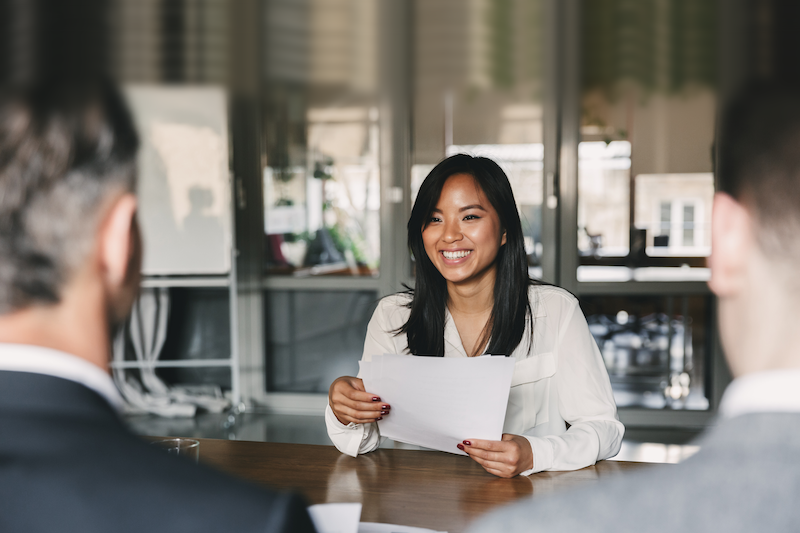 Person holding a piece of paper and smiling