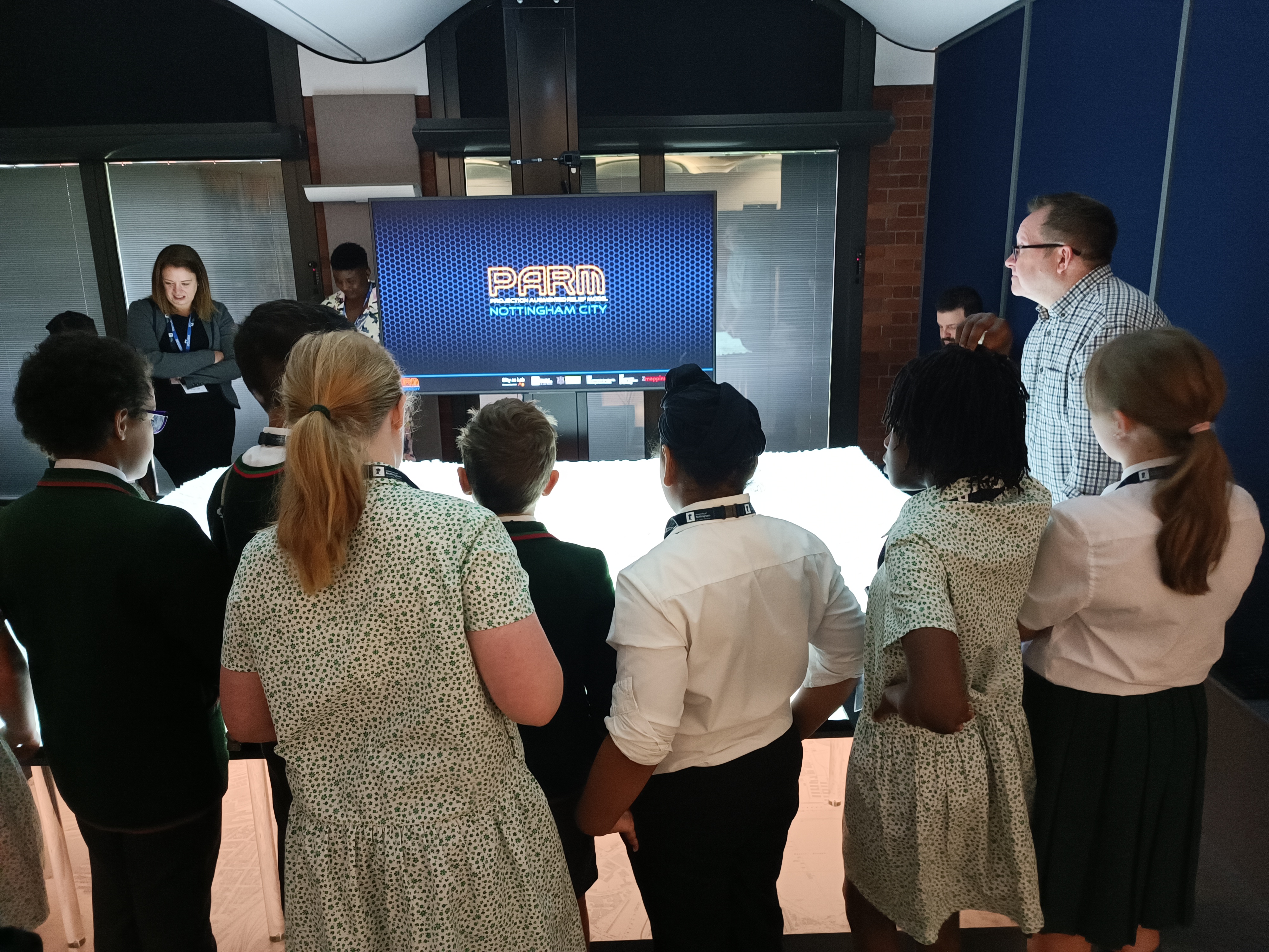 A group of school children viewing the projection augmented relief model