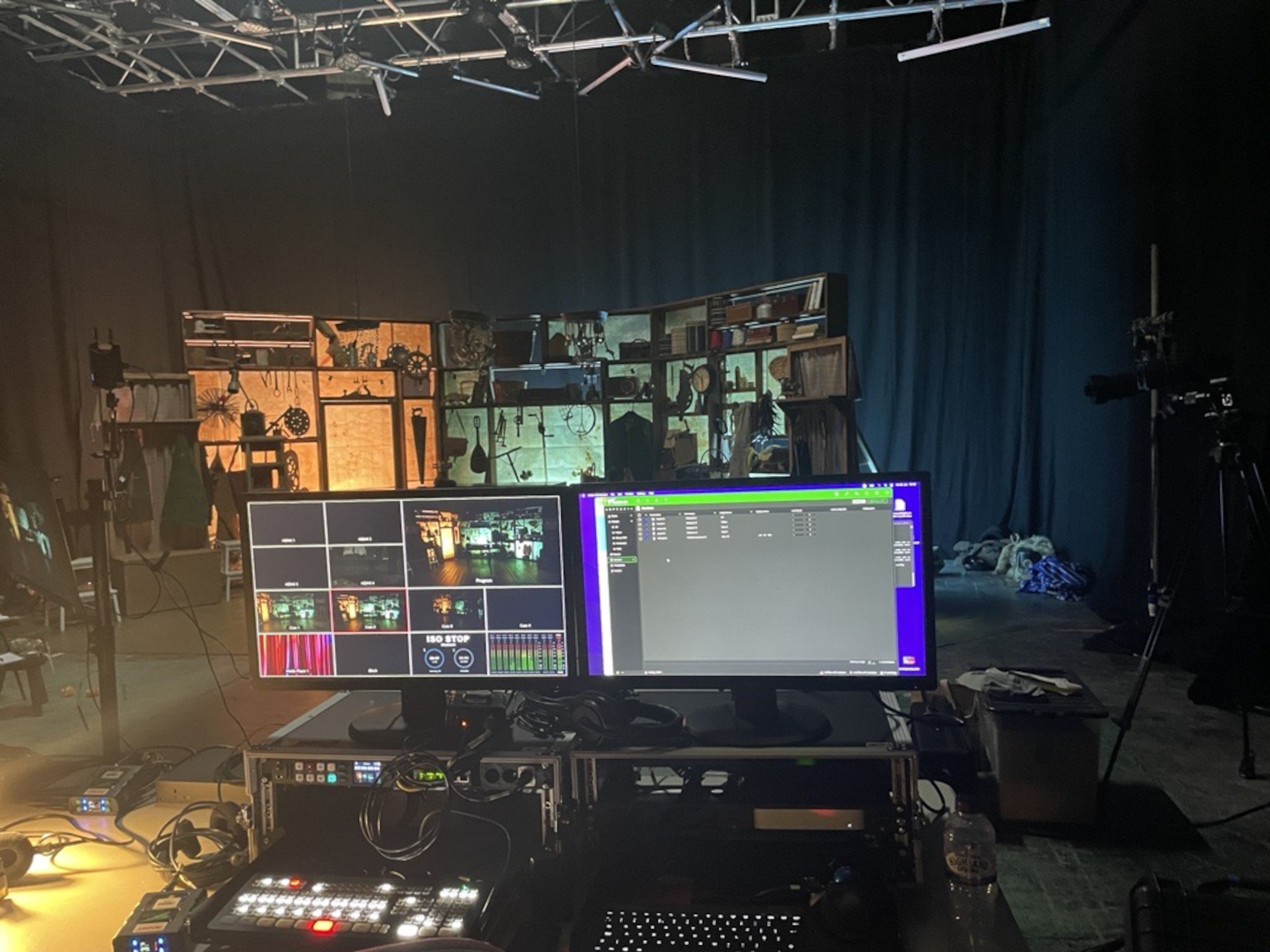 Four computer screens grouped together. They are positioned a dark recording studio