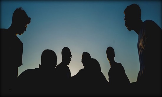 Shadow outline of a group of people against the sun