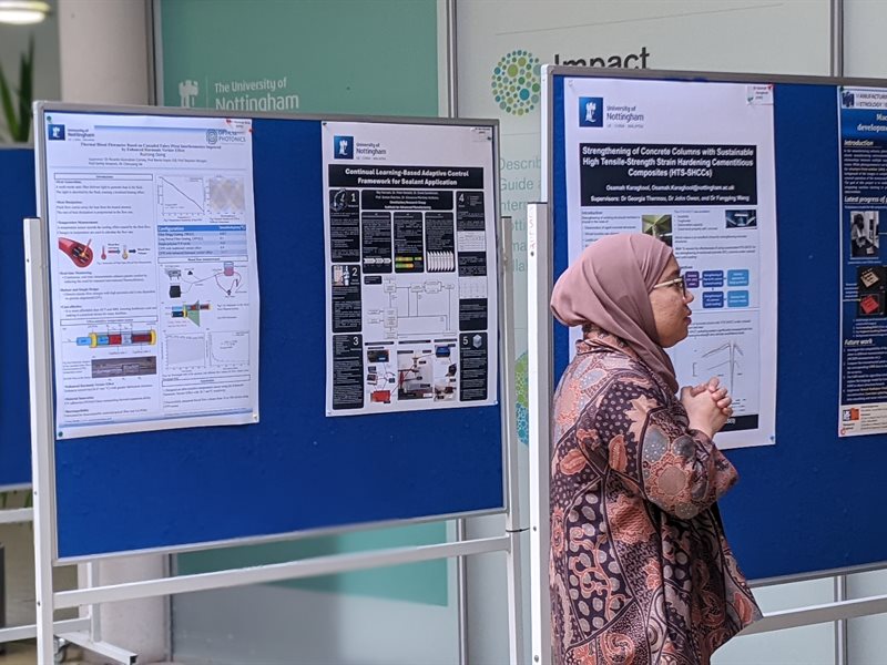 A female student reading research posters displayed in the ESLC building