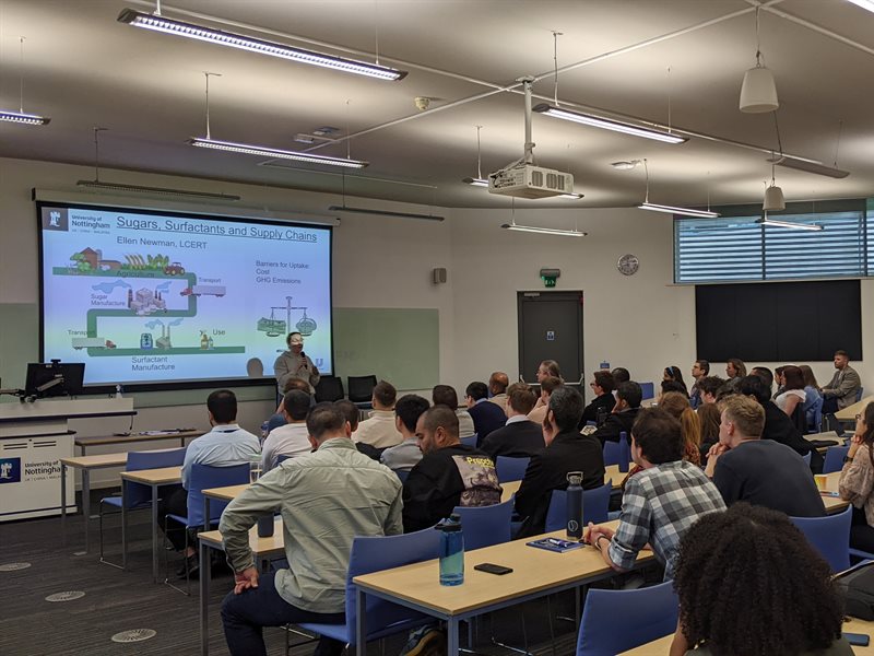 A seminar room full of students listening to research presentations by their peers