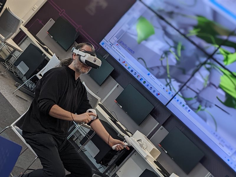 A researcher wearing a headset using the virtual reality suite in the ESLC building