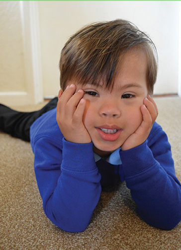 Child lying on the floor looking at the camera