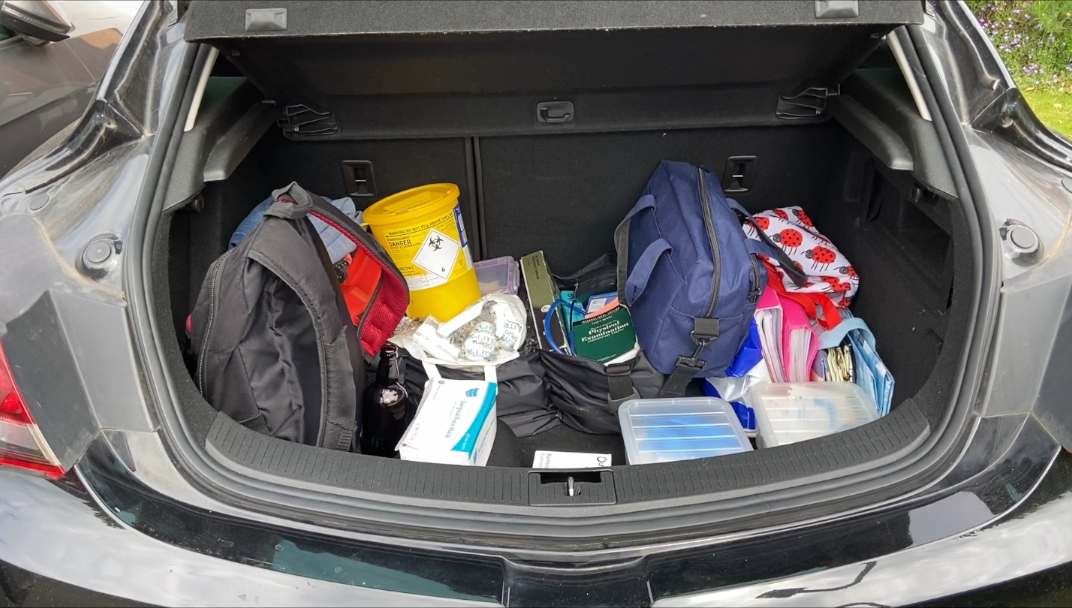 An image of the inside of the community nurses car boot containing all necessary medical equipment.