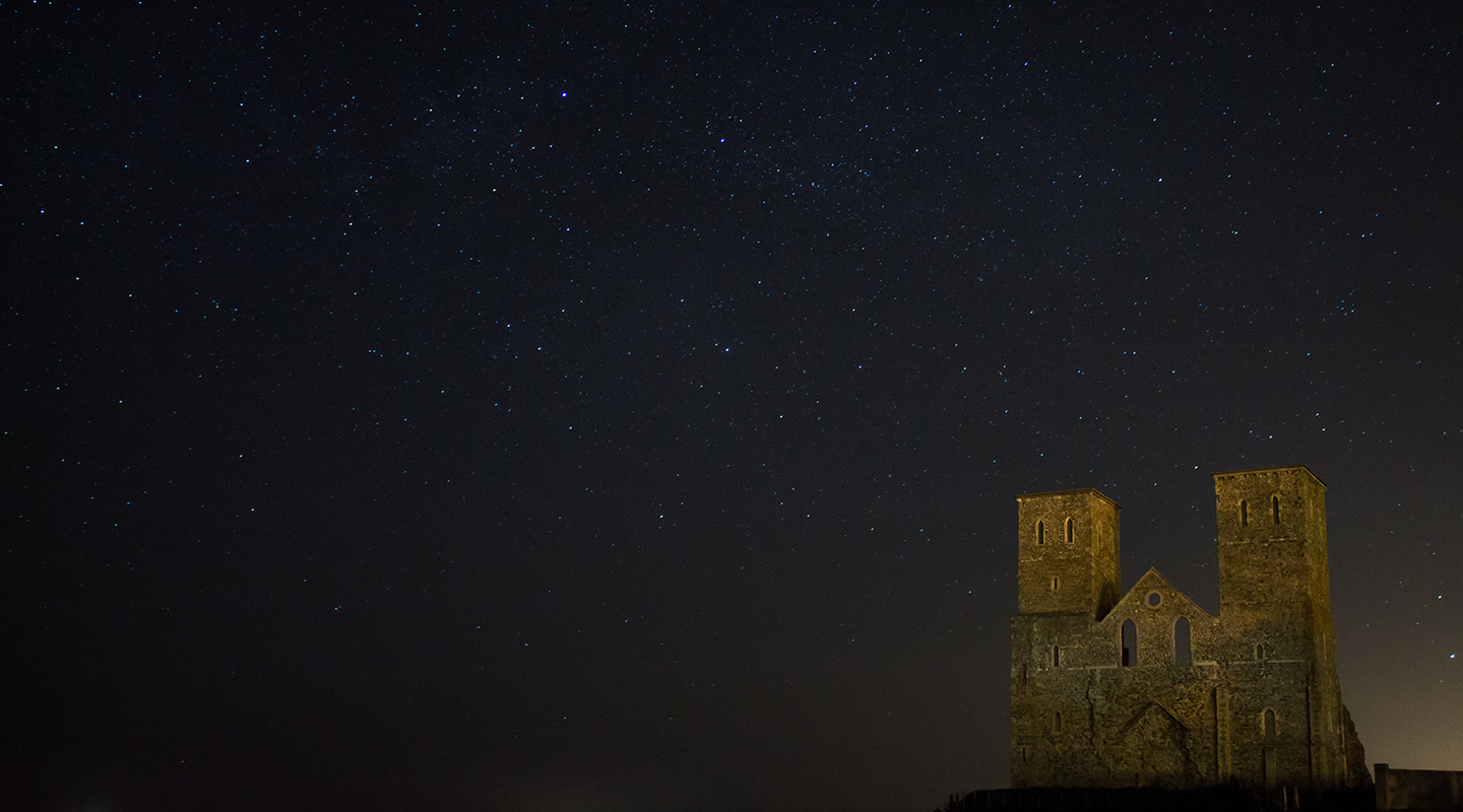 Medieval church by night under a starry sky