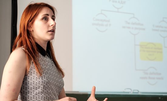 Alice Monypenny giving a talk in front of a white board