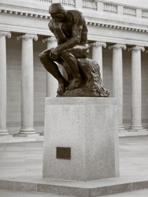 Bronze statue of "The Thinker" by Rodin in courtyard surrounded by columns