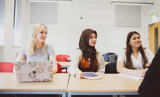 Three students sitting in seminar facing forward