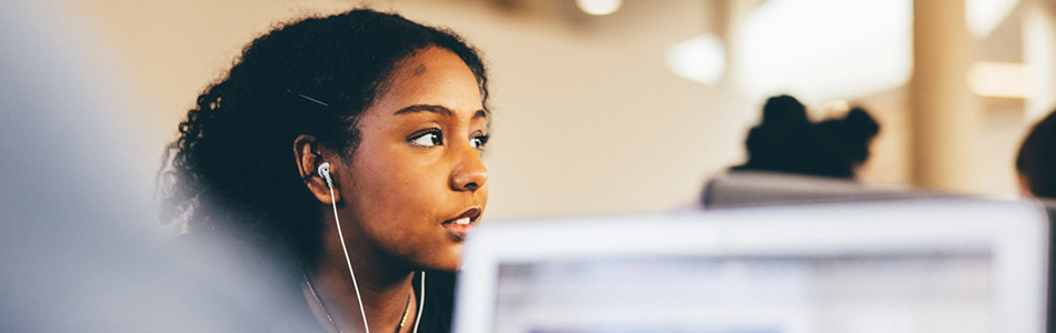 Student wearing headphones and working in George Green Library