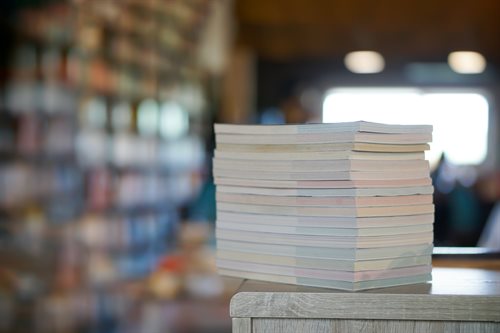 A stack of journals on a wooden shelf