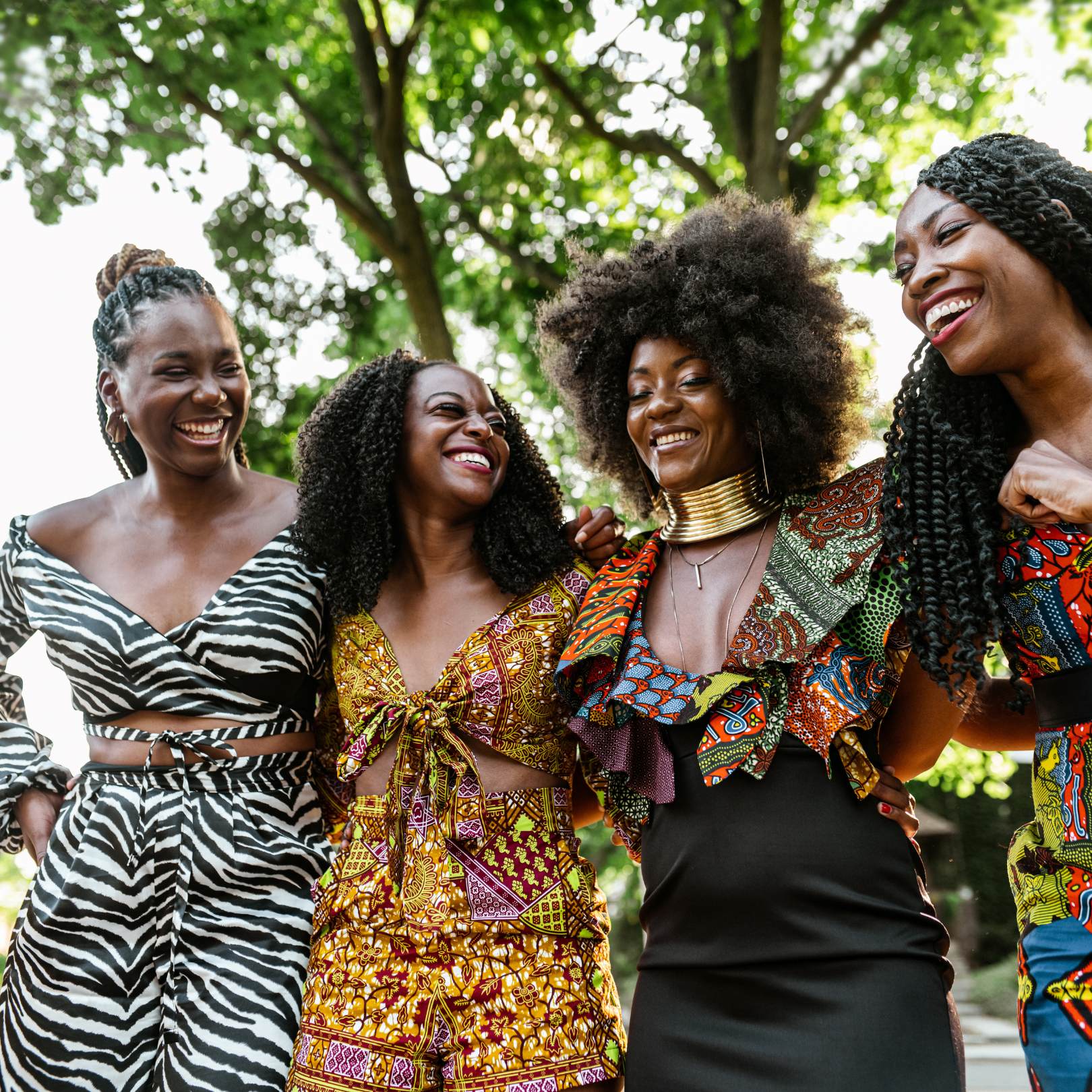 4 black women smiling and hugging each other