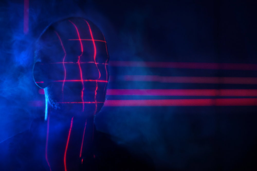 Outline of man in blue light with red lines over face